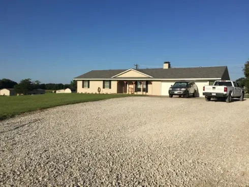 Freshly repaired gravel driveway leading up to a house.