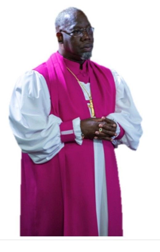 A man in a purple and white robe with his hands folded