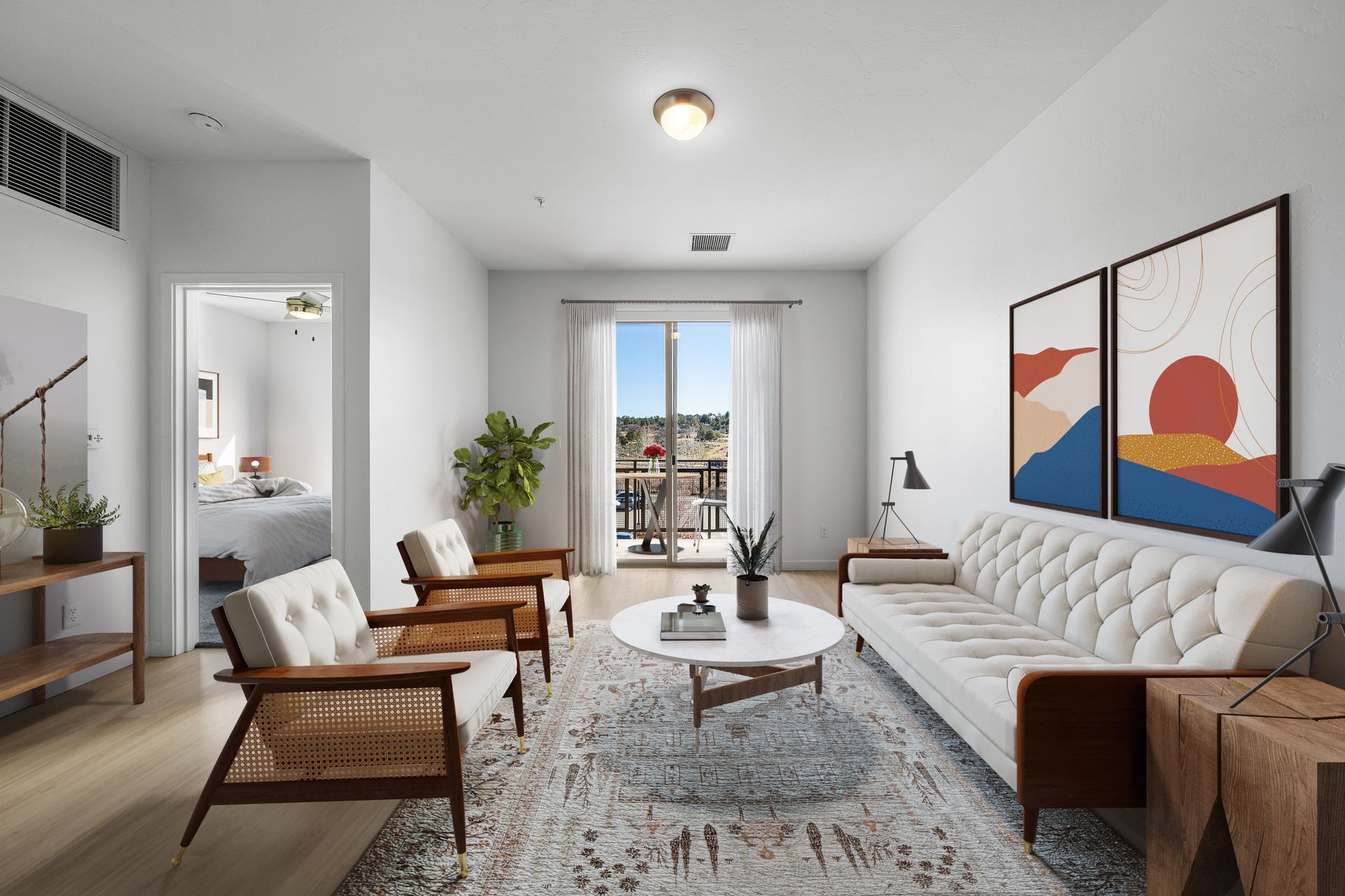 Bright apartment living room with white walls, mid-century wooden chairs, and a balcony door.