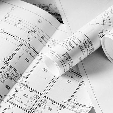 A bunch of rolls of blueprints are laying on top of each other on a table.