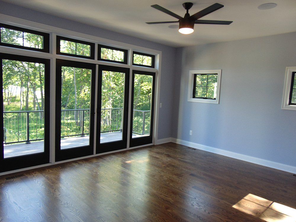 A room with a lot of windows and a ceiling fan