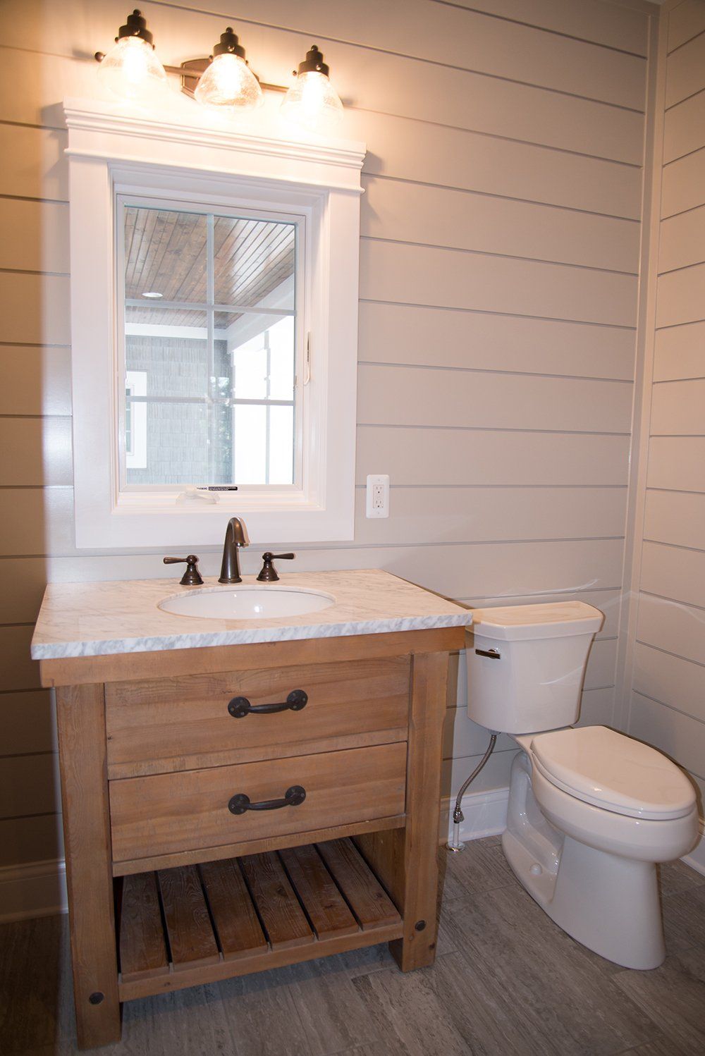 A bathroom with a sink , toilet and mirror.
