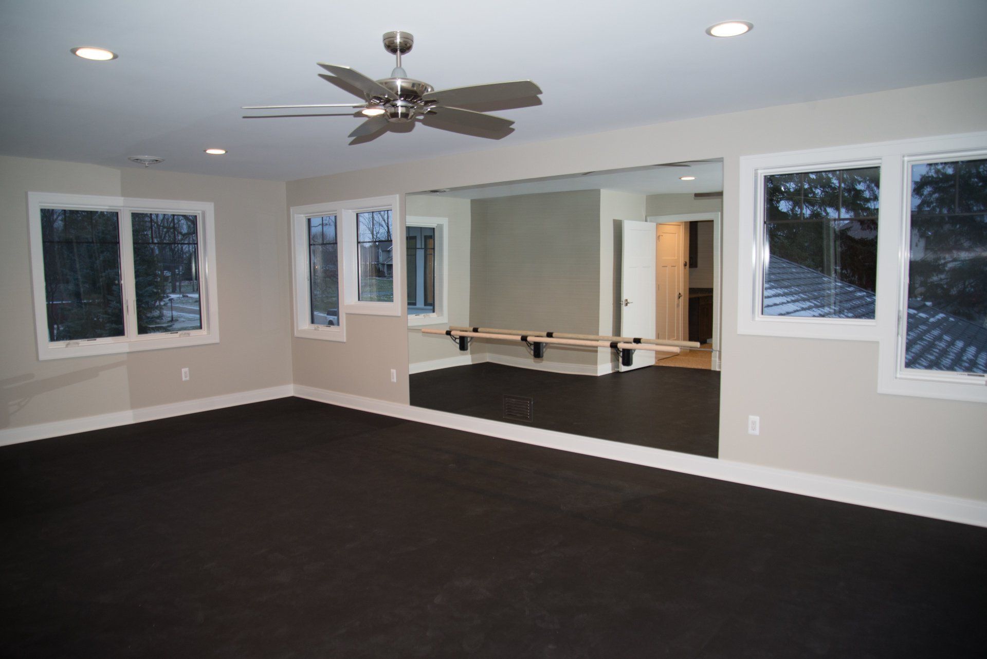 An empty room with a large mirror and a ceiling fan