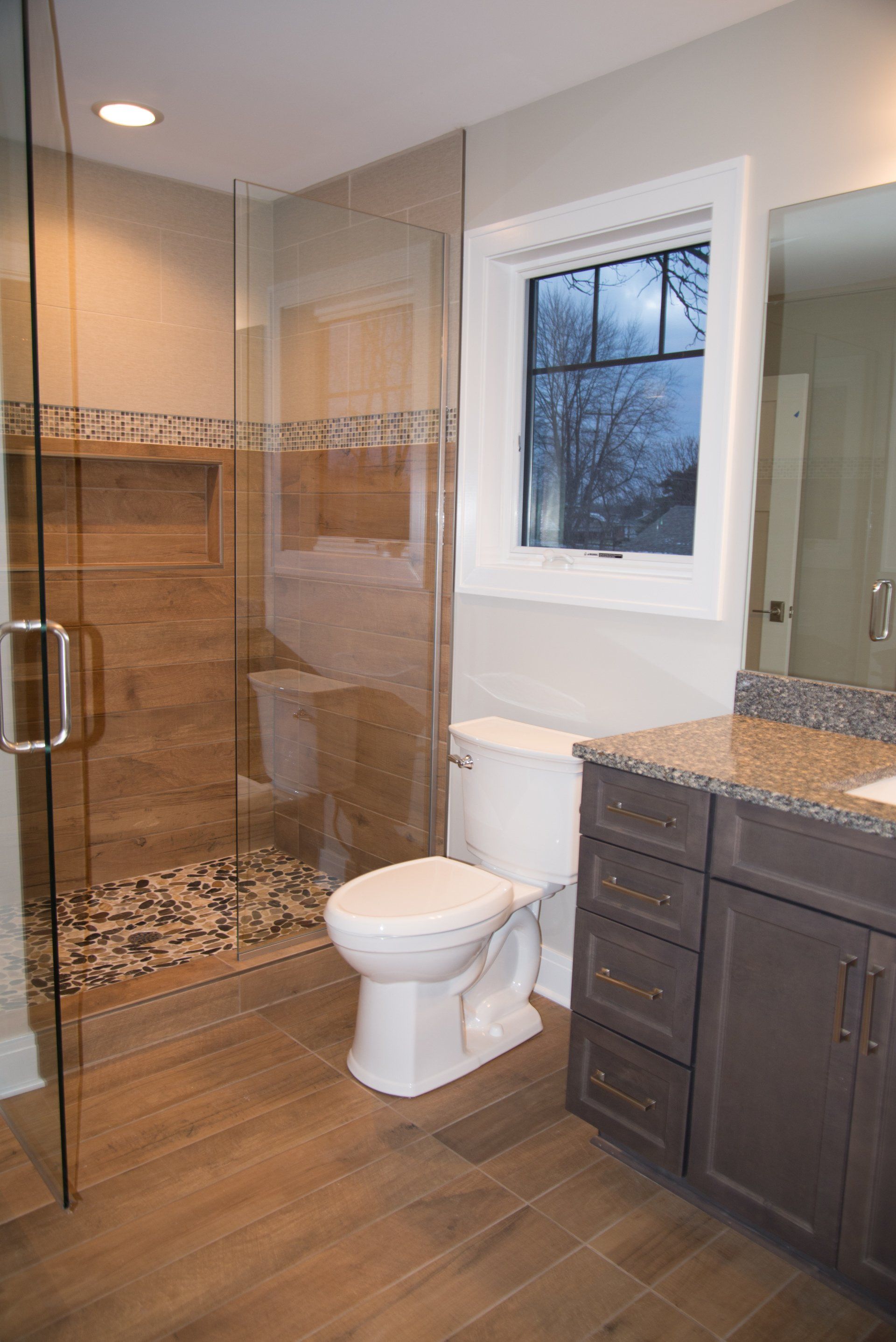 A bathroom with a toilet , sink , and walk in shower.