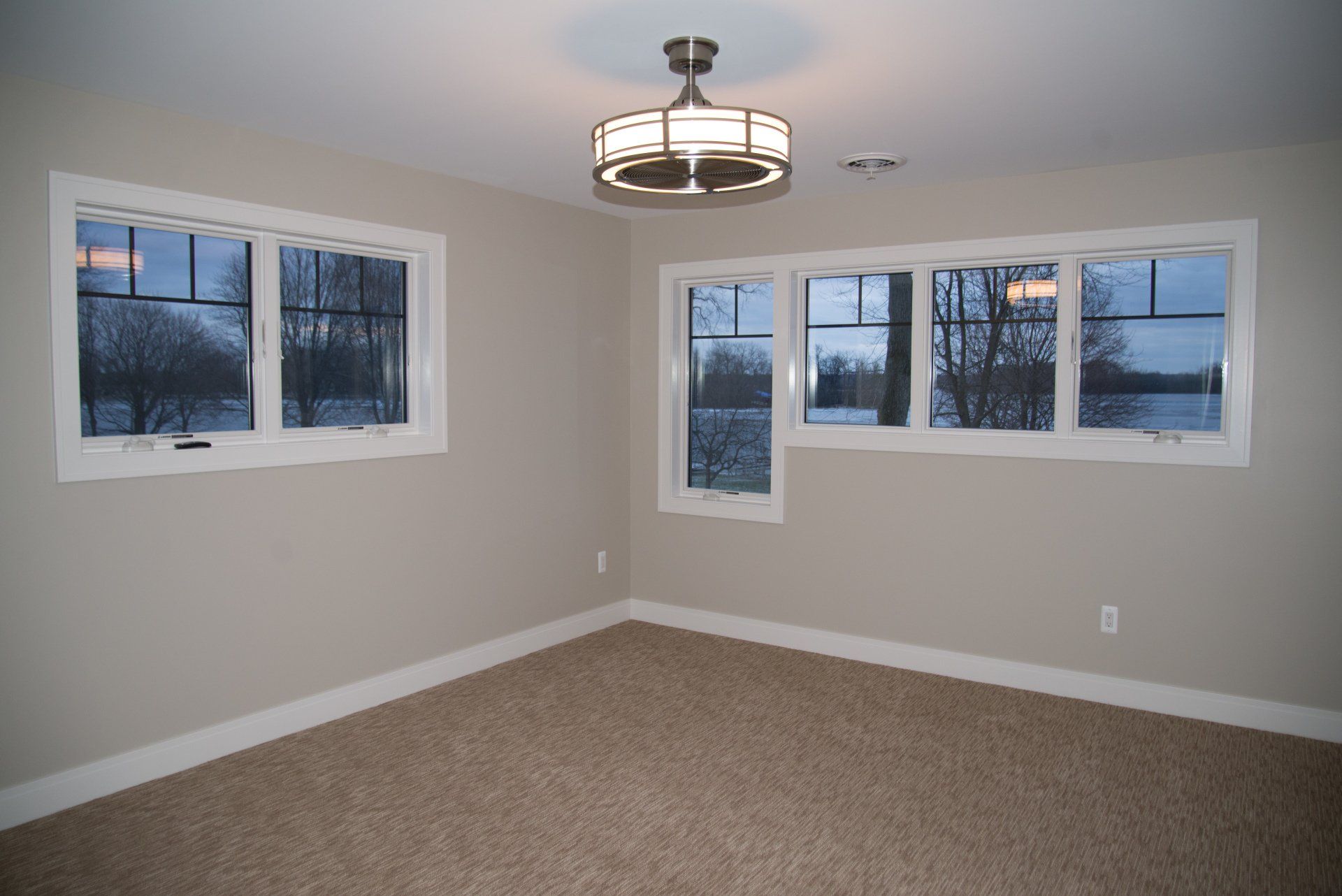 A room with a lot of windows and a ceiling fan