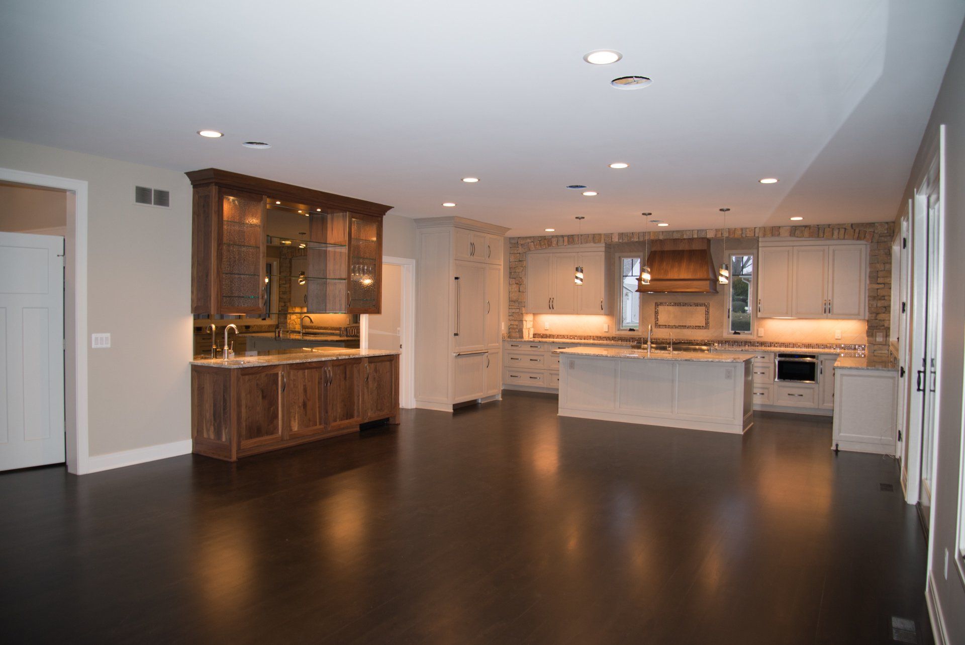 An empty kitchen with a large island in the middle of the room.