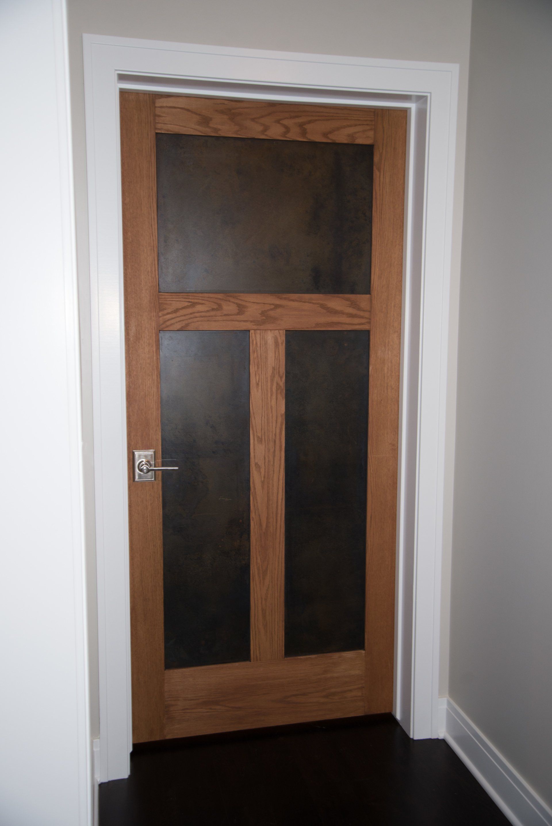 A wooden door with a black glass panel