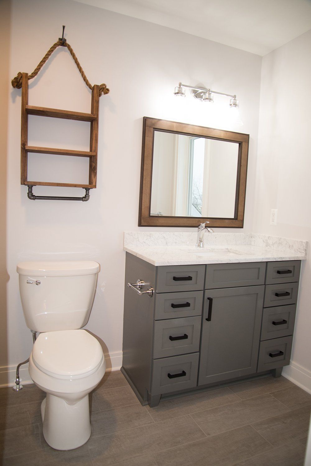 A bathroom with a toilet , sink and mirror.