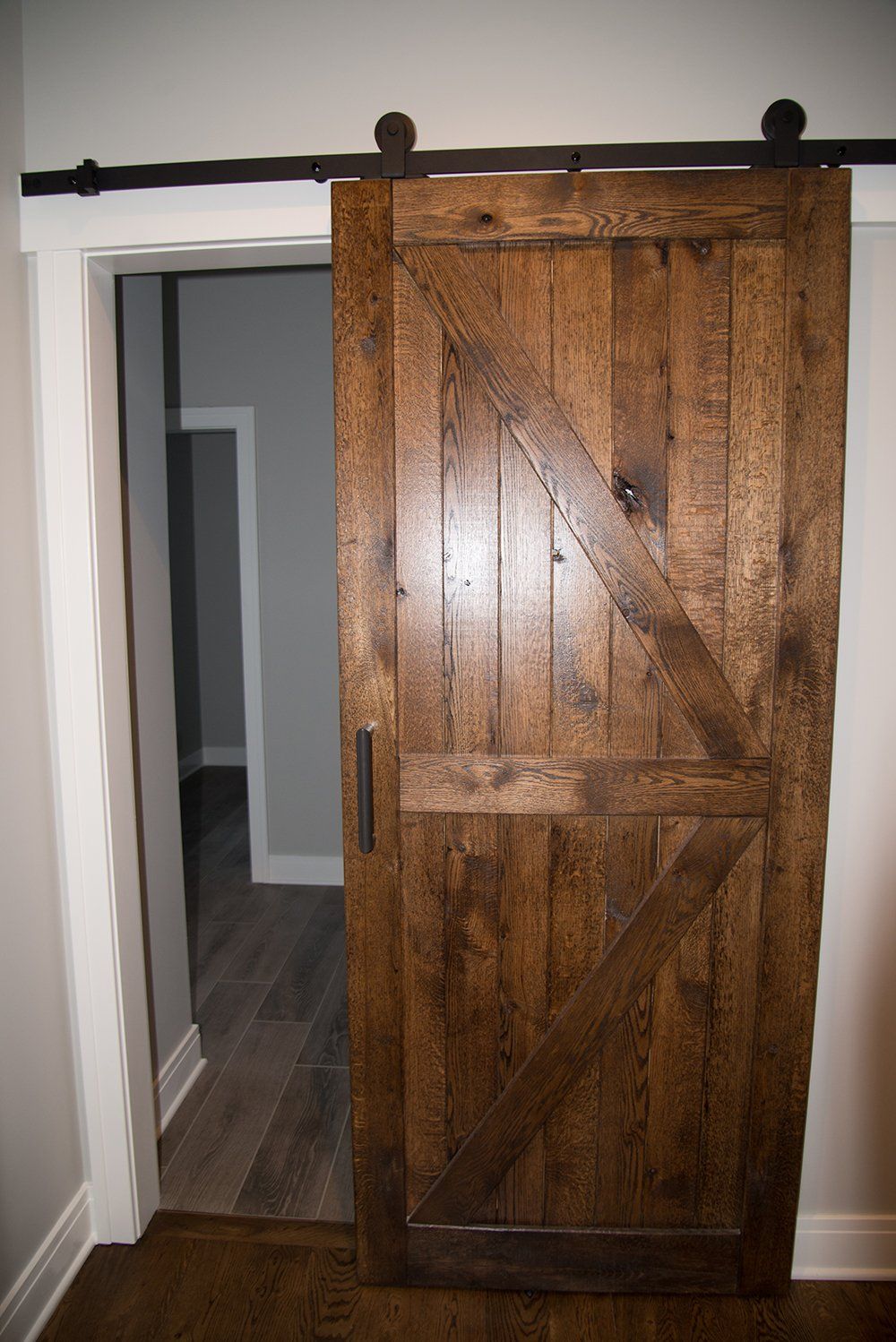A wooden sliding barn door is open in a room.