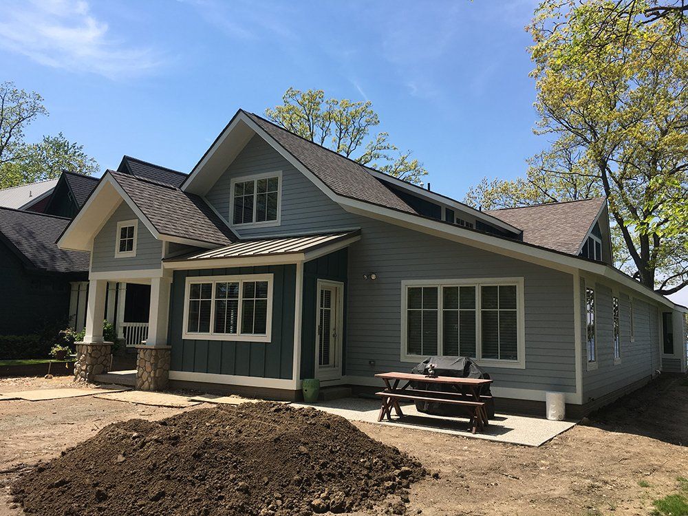 A large house with a picnic table in front of it.