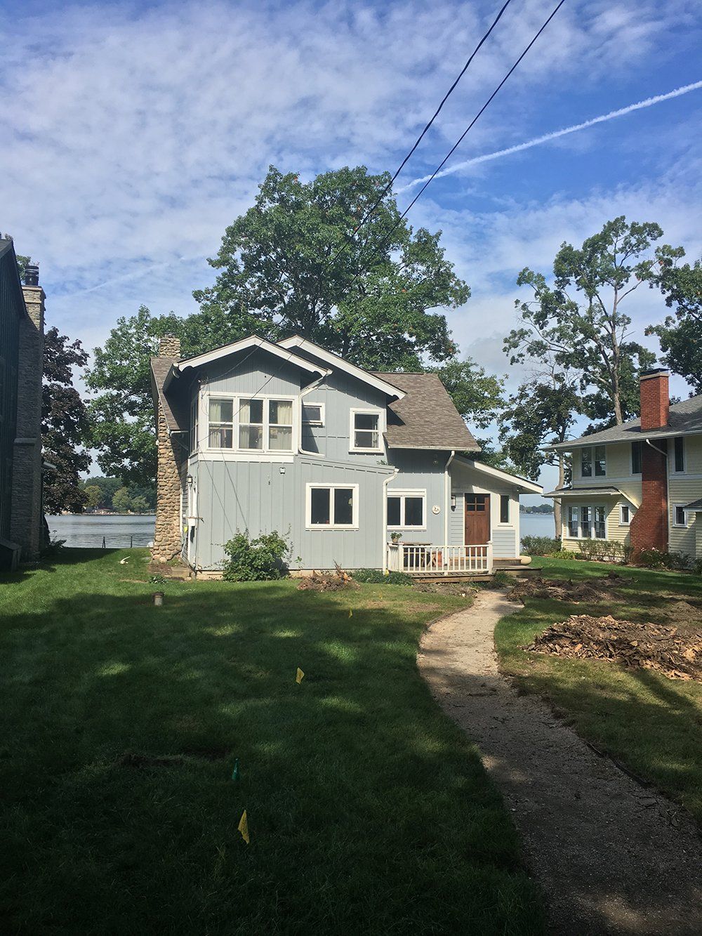 A house with a lot of windows and a lot of grass in front of it