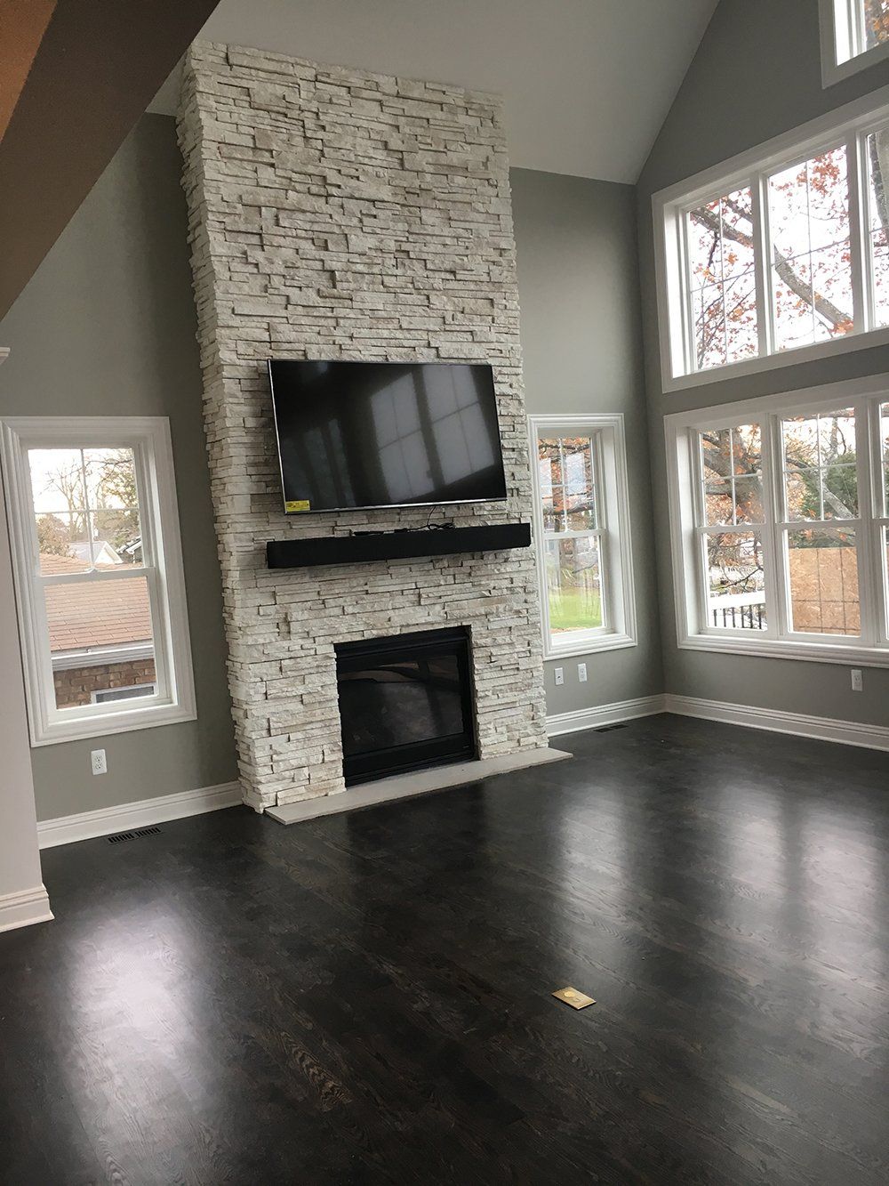 A living room with a fireplace and a flat screen tv on the wall.