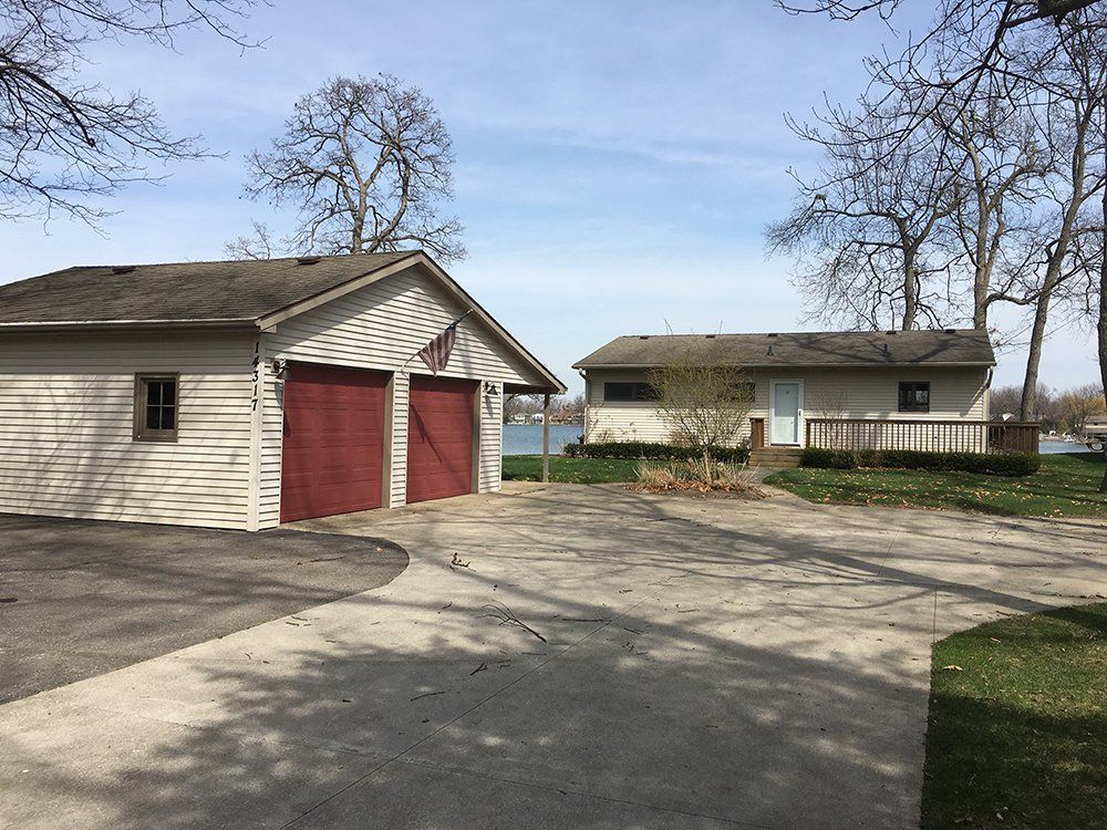 A white house with a red garage next to it.