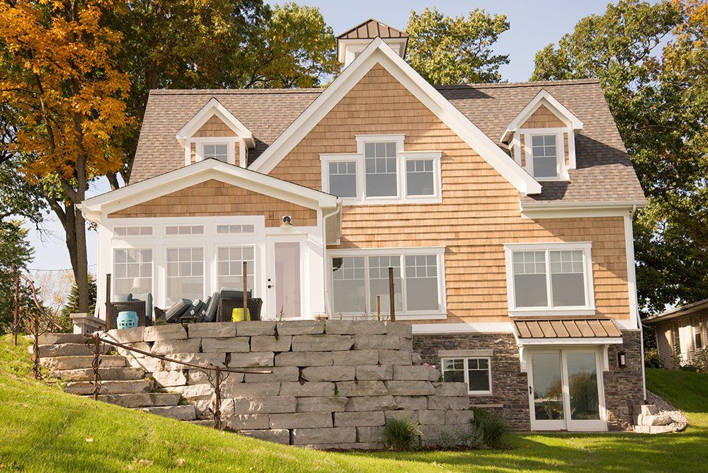 A large house with a stone wall in front of it