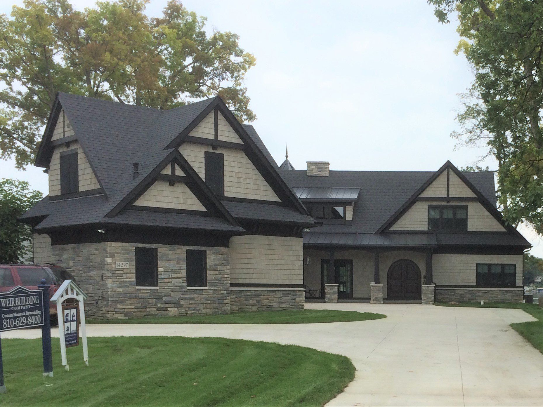 A large brick house with a black roof is for sale