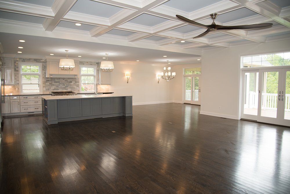 A large empty room with hardwood floors and a ceiling fan.