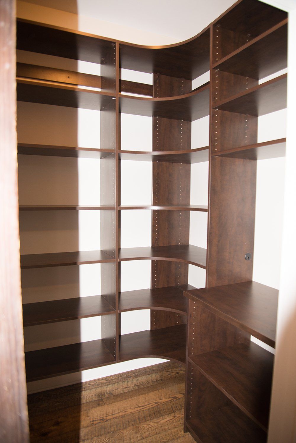 A walk in closet with lots of shelves and a drawer.