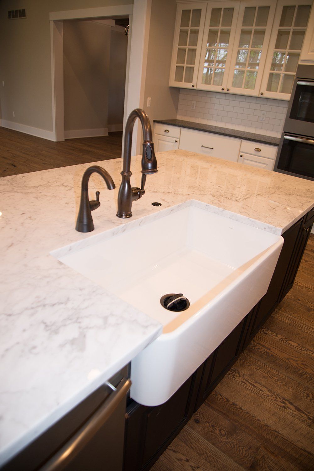 A kitchen with a white sink and a faucet on the counter.
