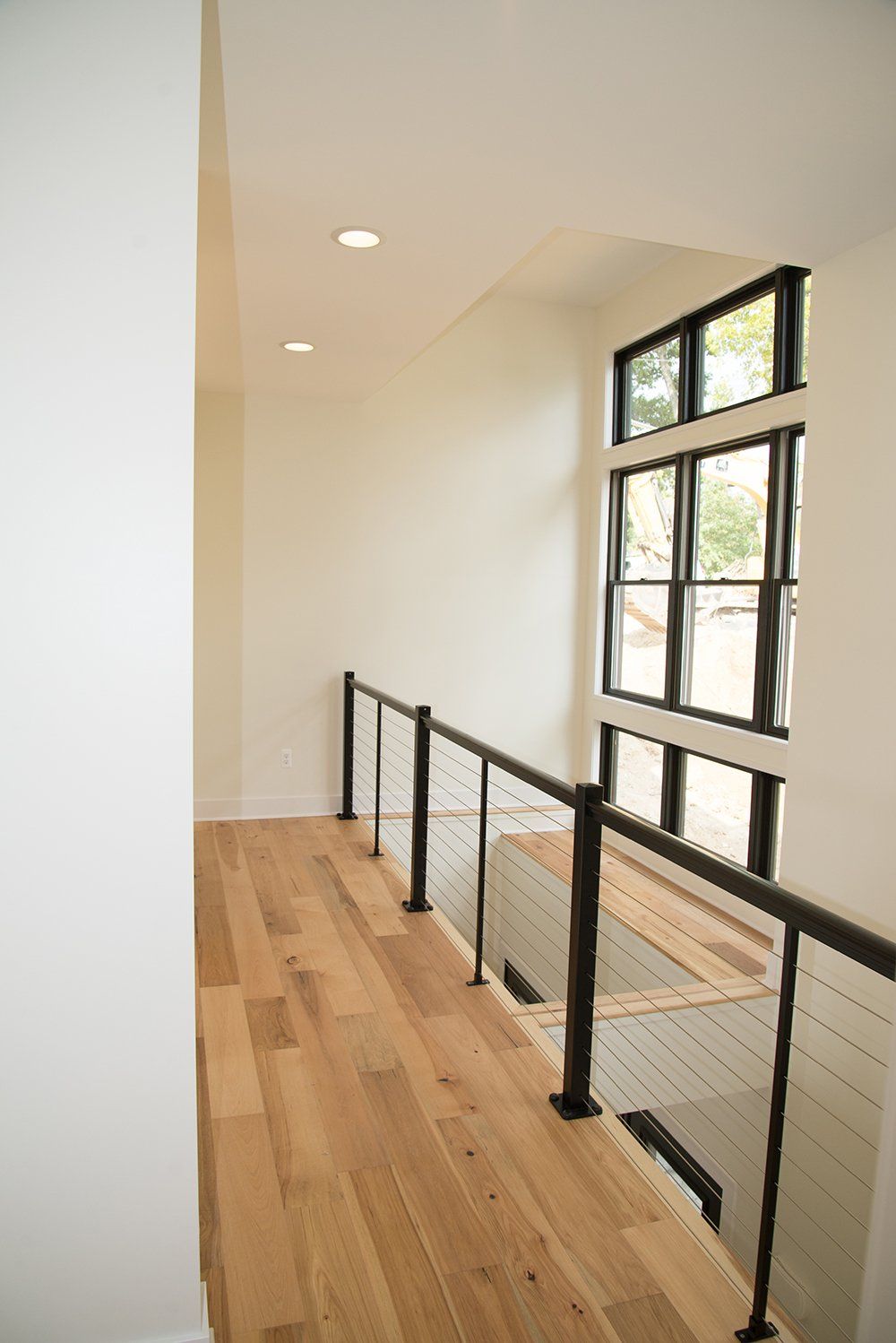 A staircase with a wooden floor and a metal railing in a house.