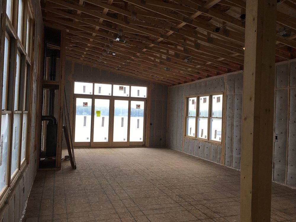 An empty room with a lot of windows and a ladder