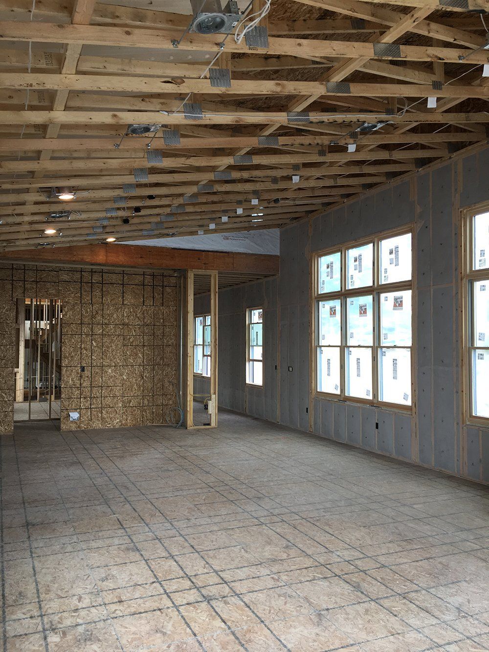 An empty room with a lot of windows and a wooden ceiling.