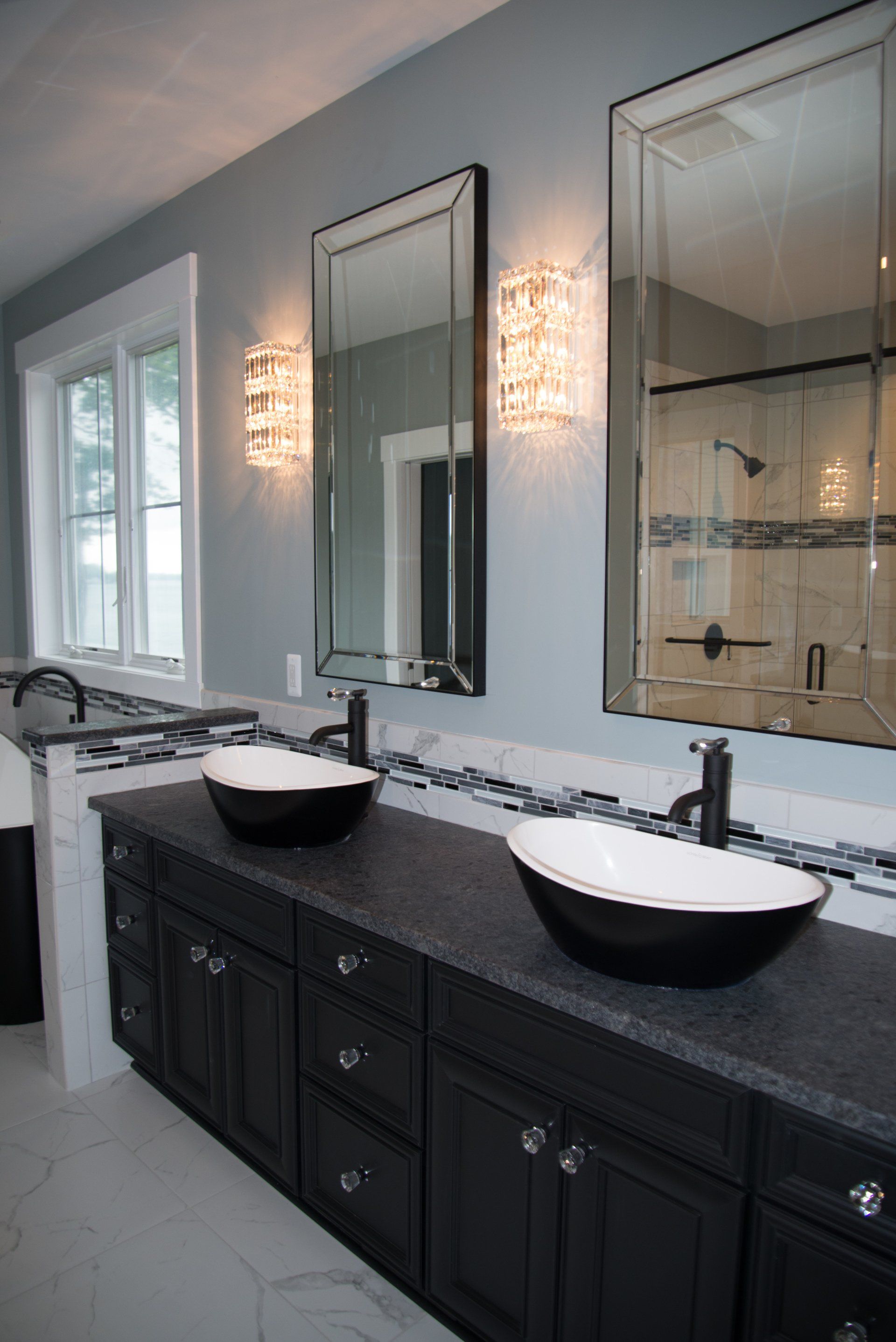 A bathroom with two sinks and two mirrors