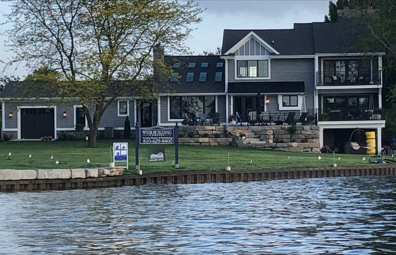 A large house sits on the shore of a lake.