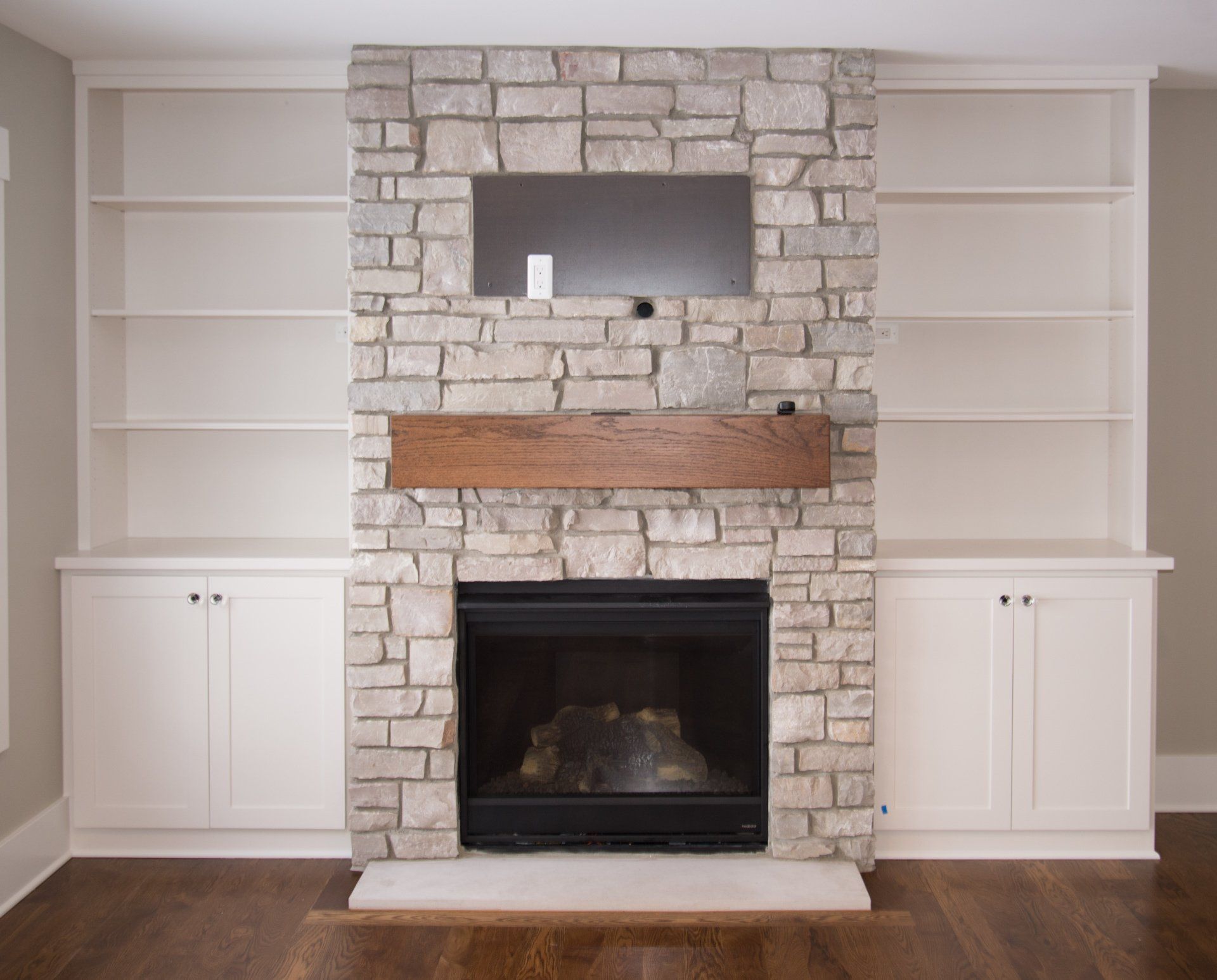 A living room with a fireplace and built in shelves