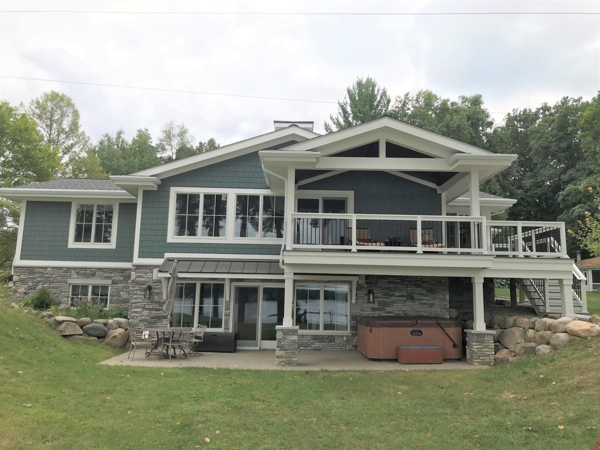 A large house with a large deck and a hot tub