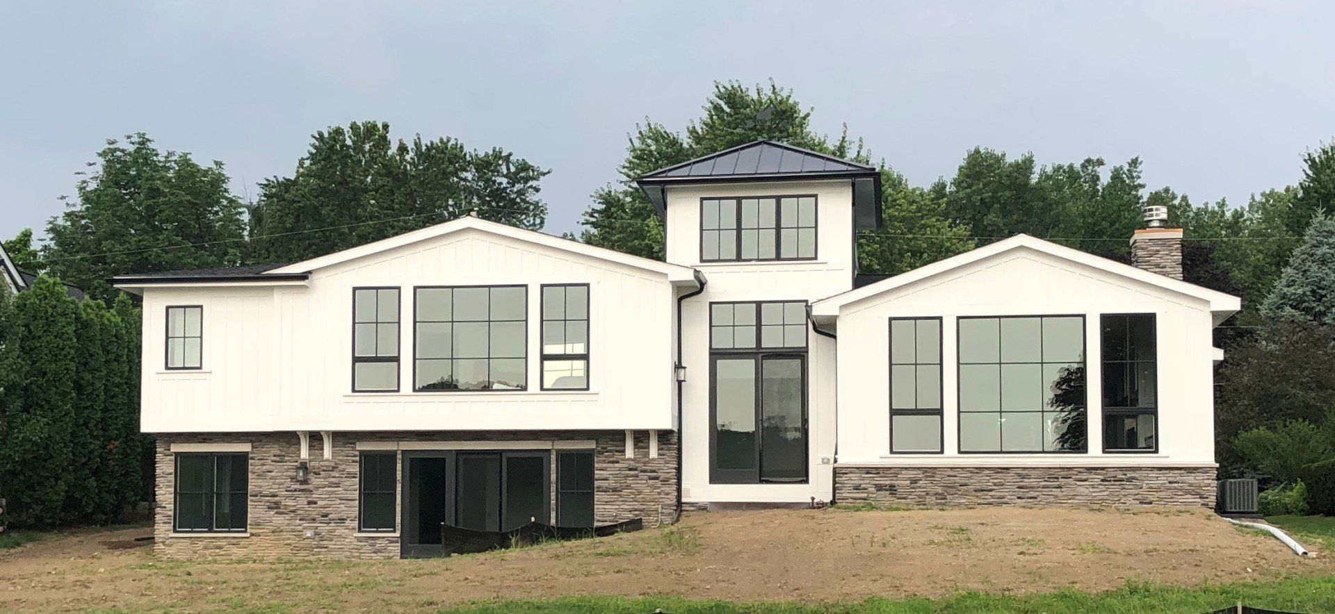 A large white house with a lot of windows is surrounded by trees