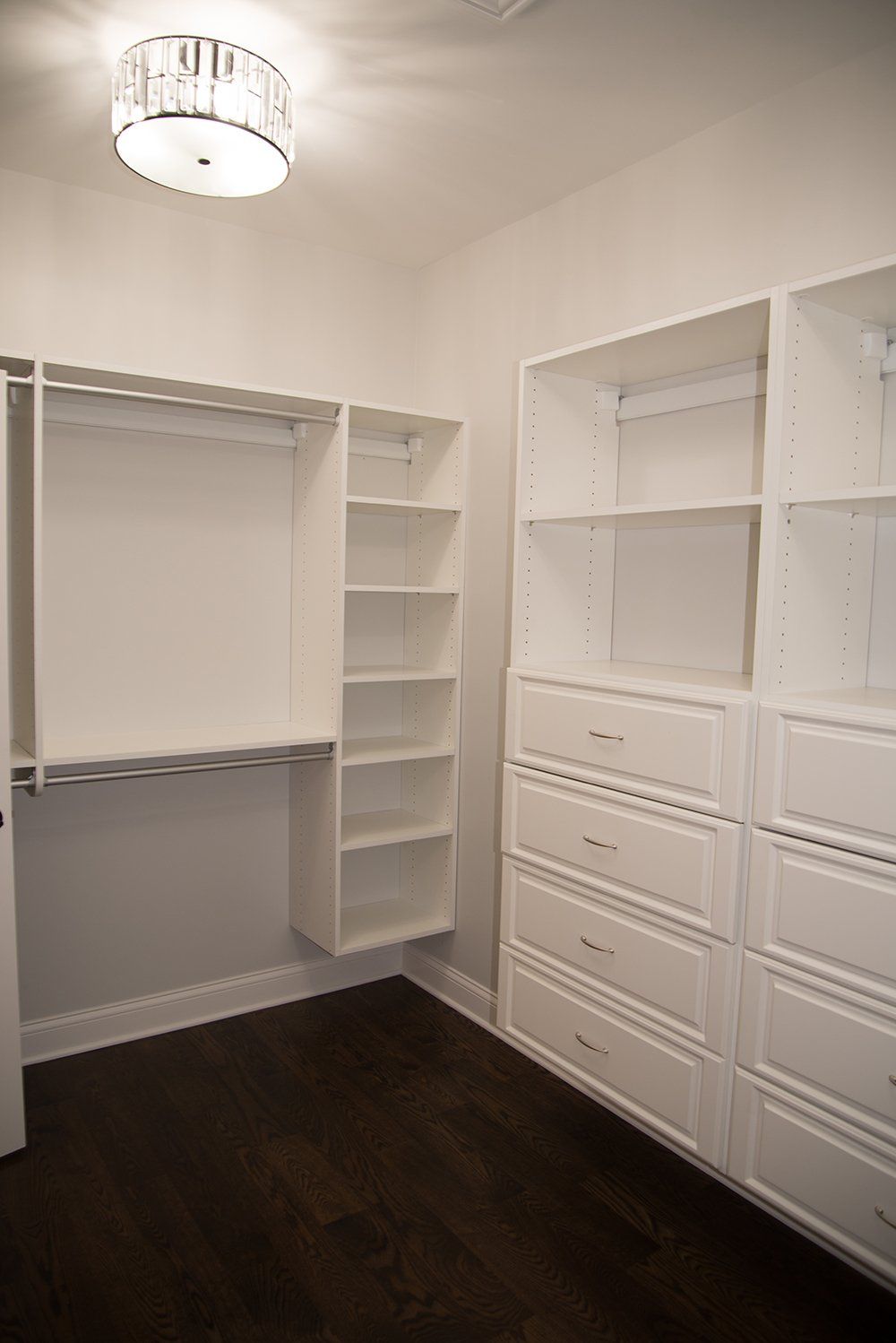 A walk in closet with lots of shelves and drawers