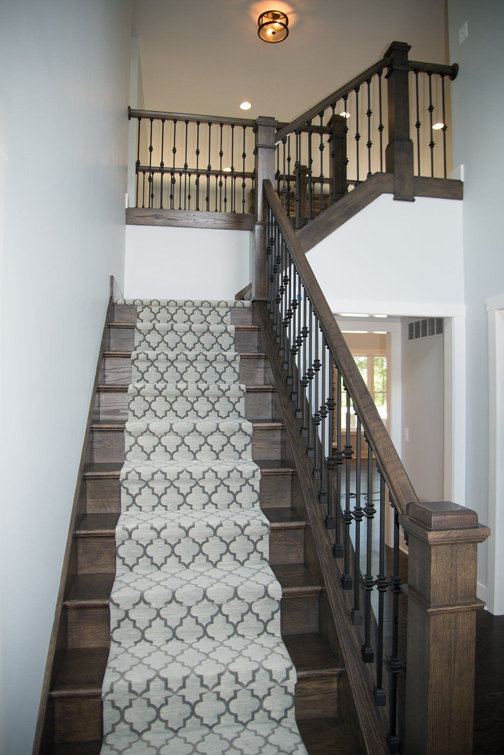 A wooden staircase with a carpeted staircase leading up to the second floor of a house.