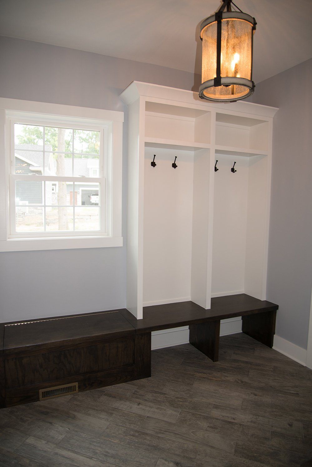 A mud room with a bench and a lantern hanging from the ceiling.