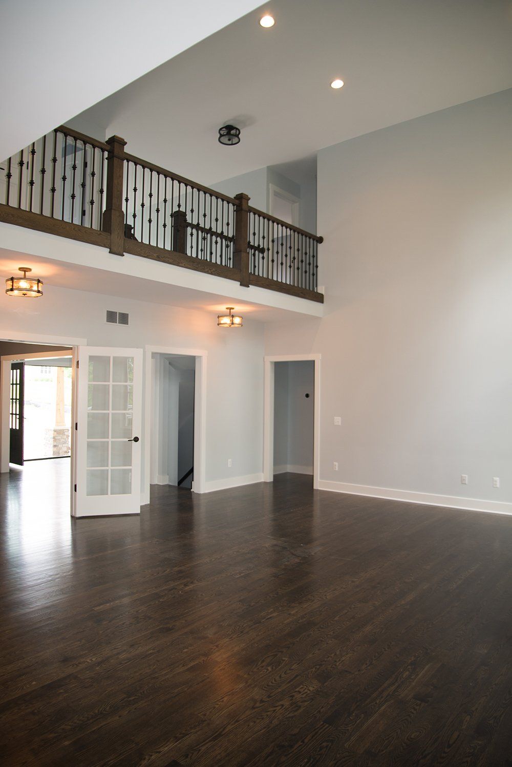 An empty living room with a balcony and stairs
