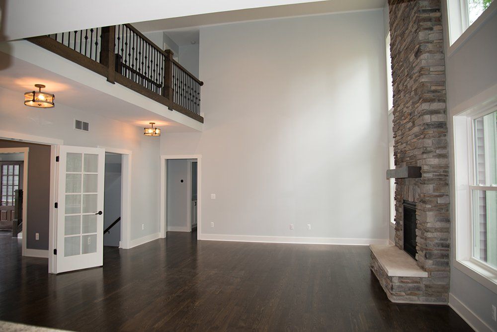 An empty living room with a fireplace and stairs