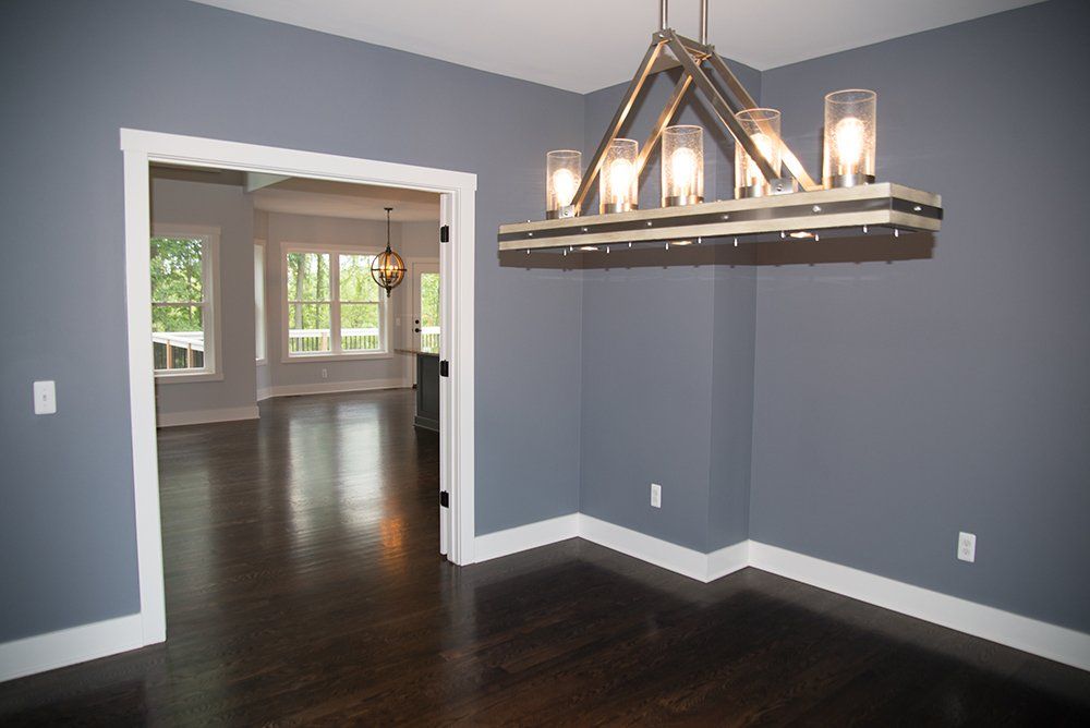 An empty room with a chandelier hanging from the ceiling