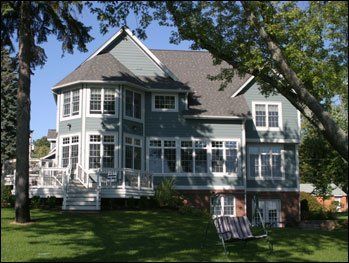 A large house with a lot of windows and a porch