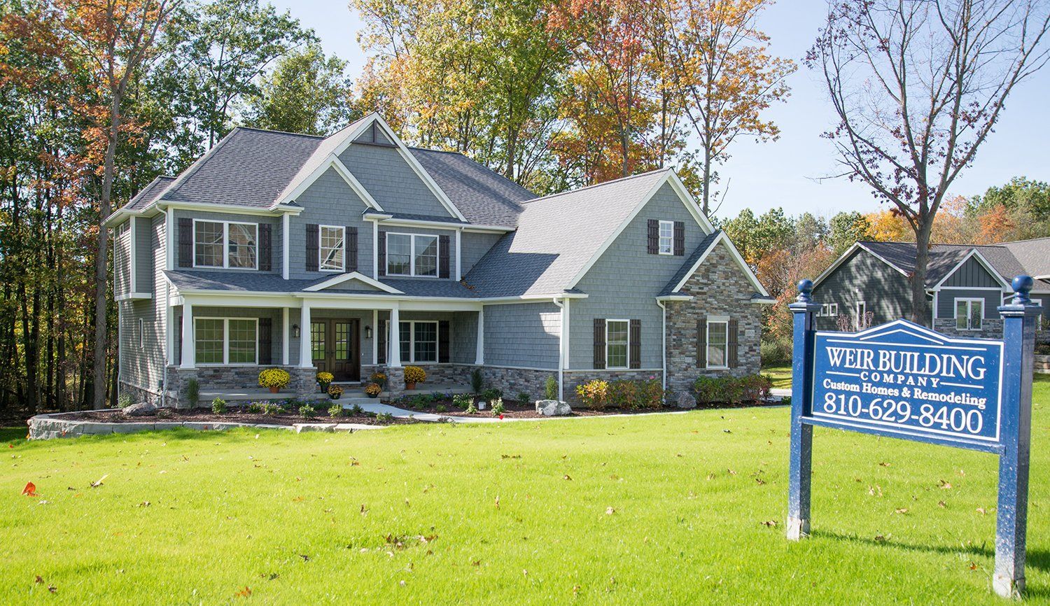 A house with a for sale sign in front of it.