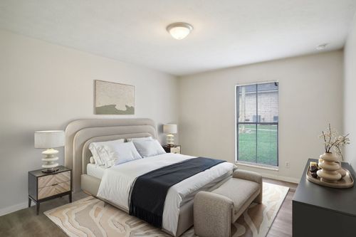 Bedroom with bed, nightstands, window, artwork, and a bench.