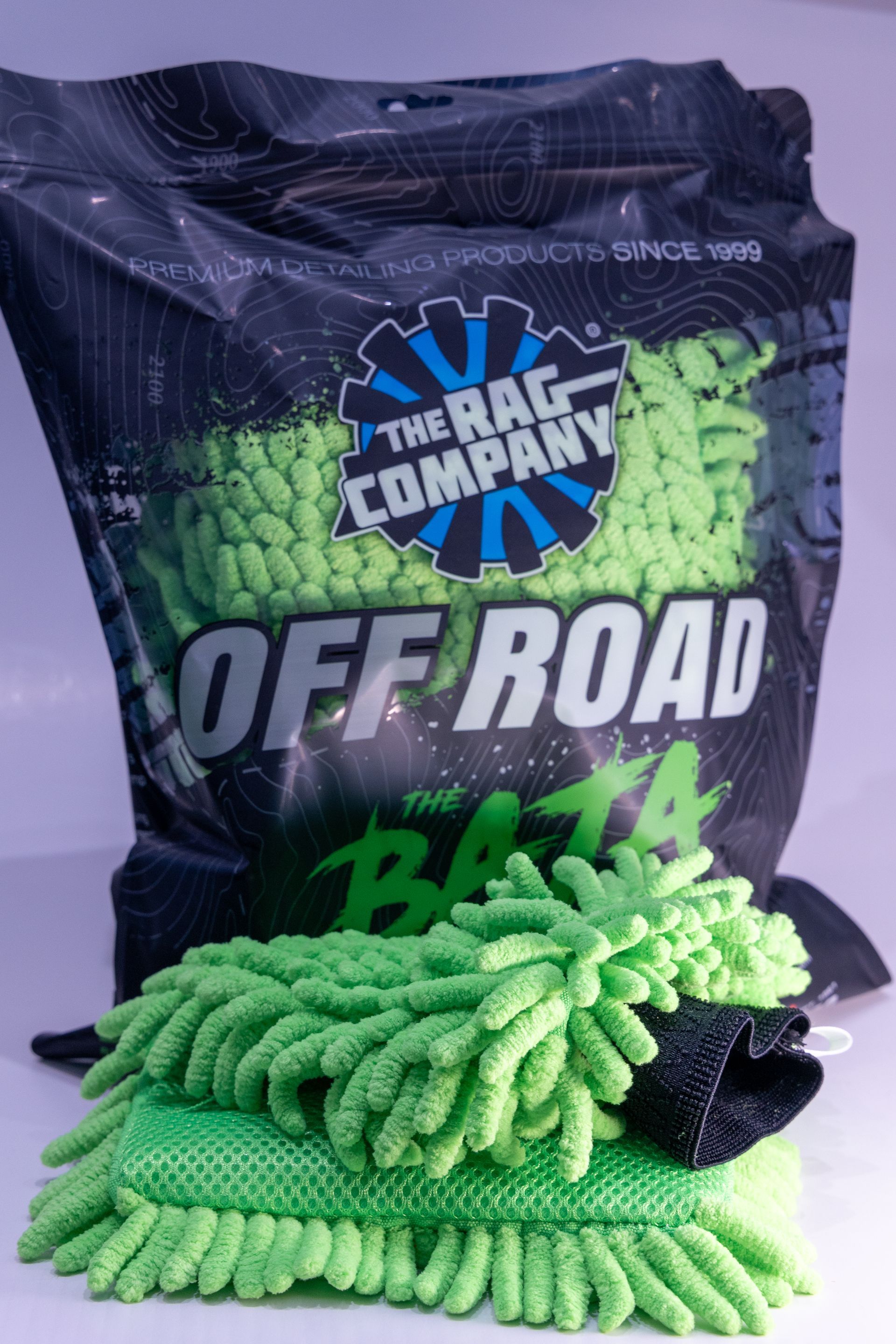 A bag of off road products is sitting next to a professional microfiber wash mitt.