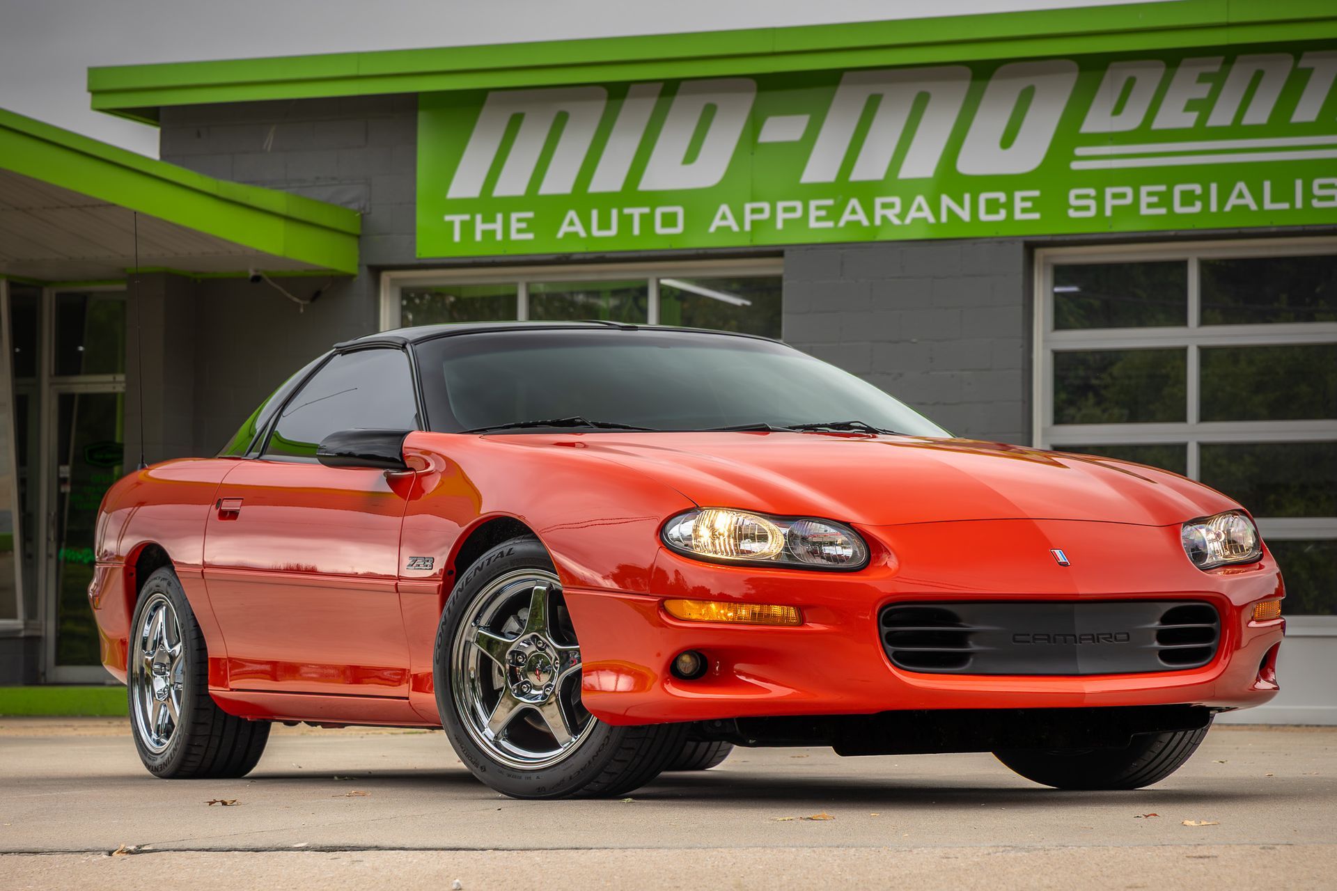 Orange Chevrolet Camaro in front of