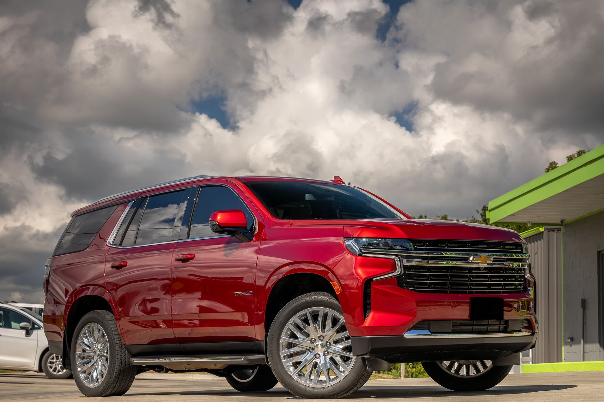 Red Chevrolet Tahoe SUV parked on a sunny day.