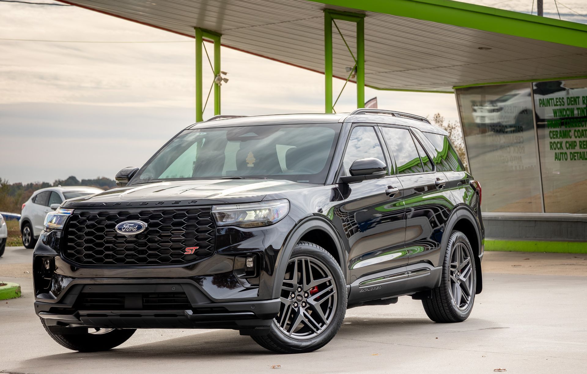 Black Ford Explorer SUV parked under a green canopy.