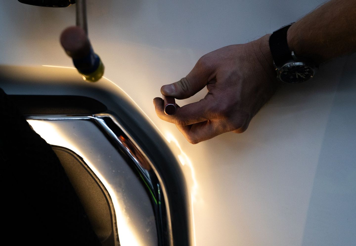 Paintless dent repair. Knocking down high spots on a dent to make the dent disappear.