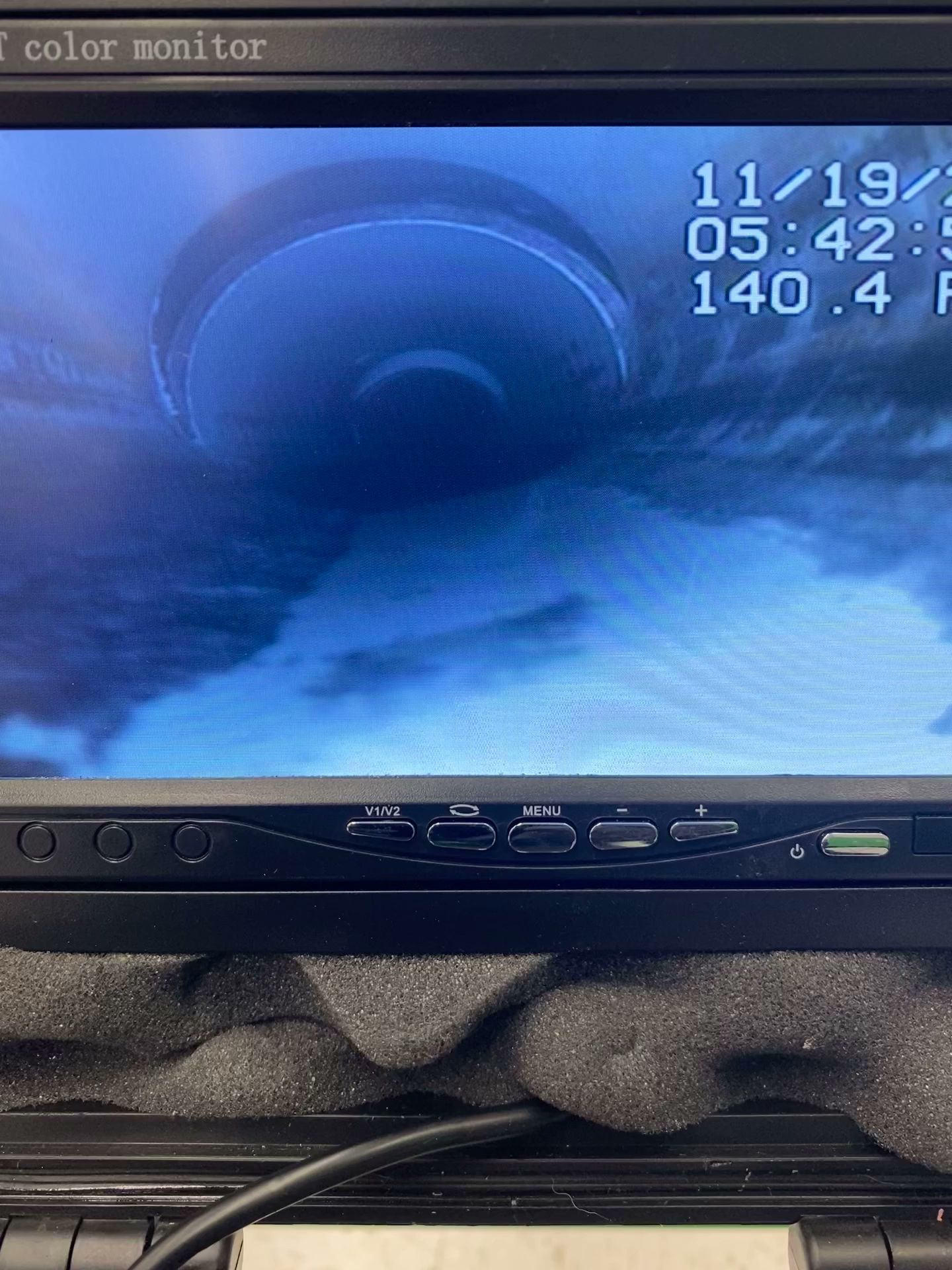 Monitor displaying a large, circular object above clouds. Date/time: 11/19/23, 05:42:50. Monitor buttons visible.