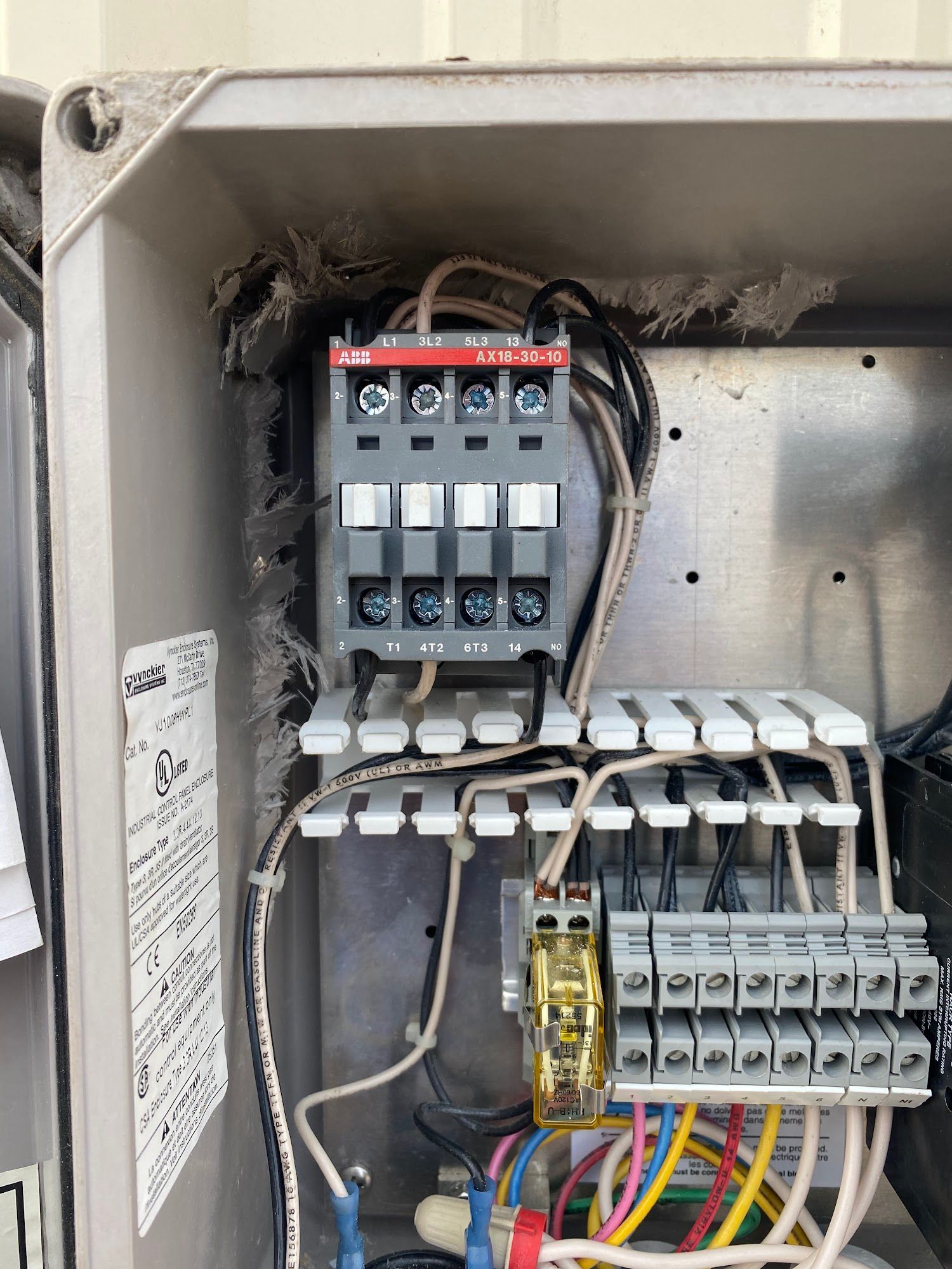 Electrical panel with wiring, ABB contactor, and terminal blocks. Gray box with visible wires.