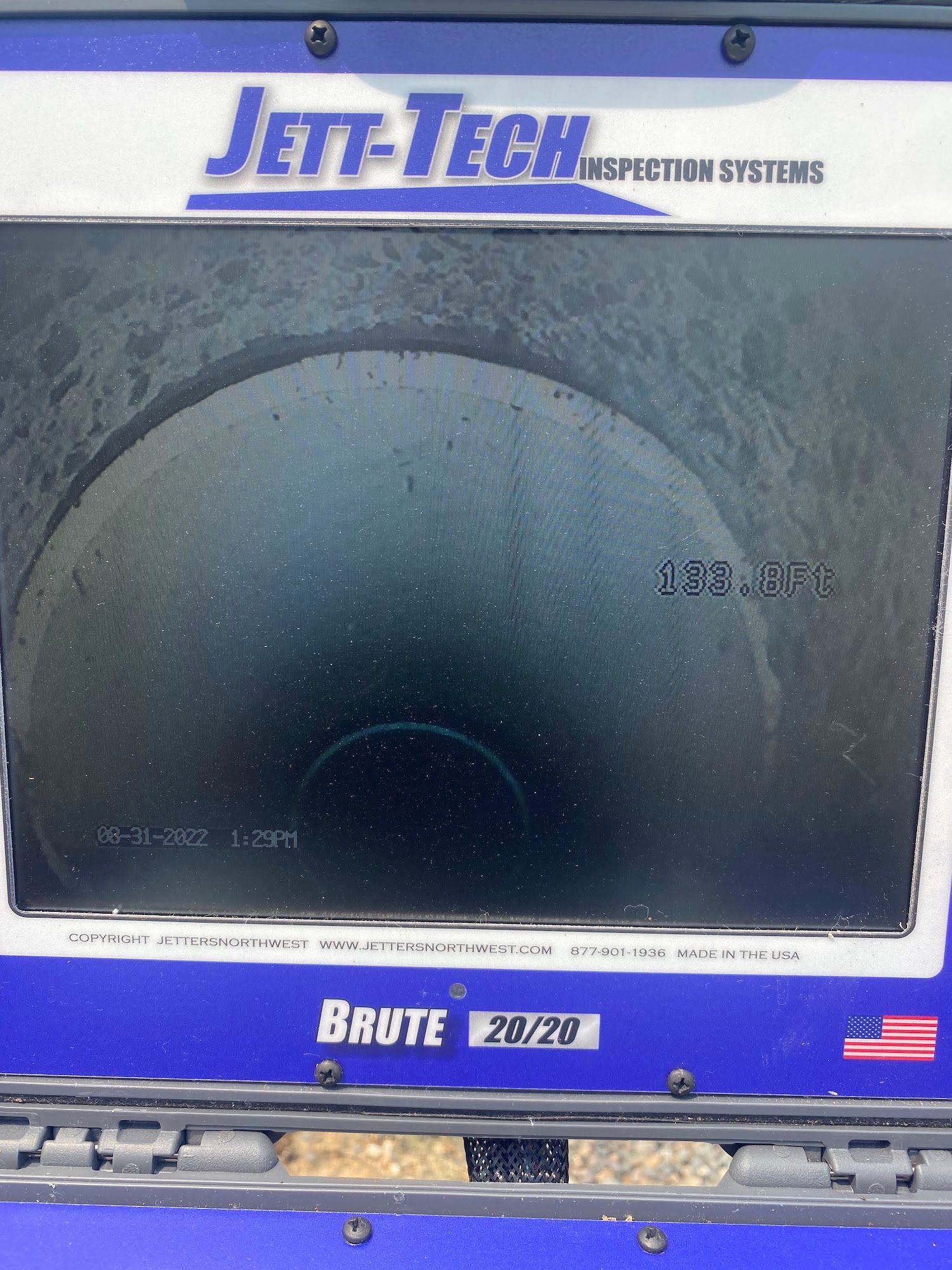 Orange Jeep Wrangler with black hood, bumper, and wheels in a garage.