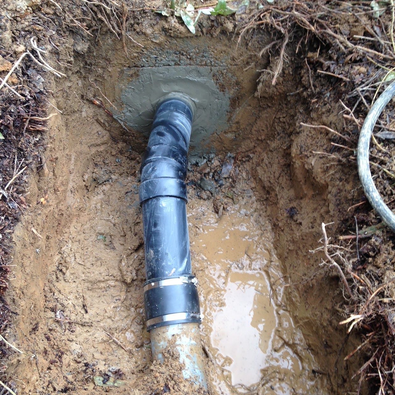 Black Range Rover parked on a residential street with black rims, against a clear blue sky.