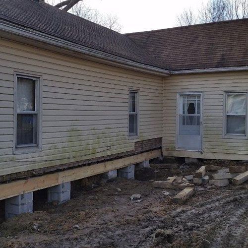 A house with a lot of windows and a door is being demolished.