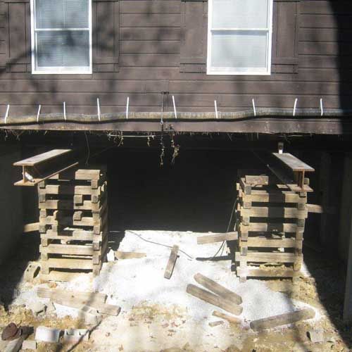 A wooden structure is being built underneath a house